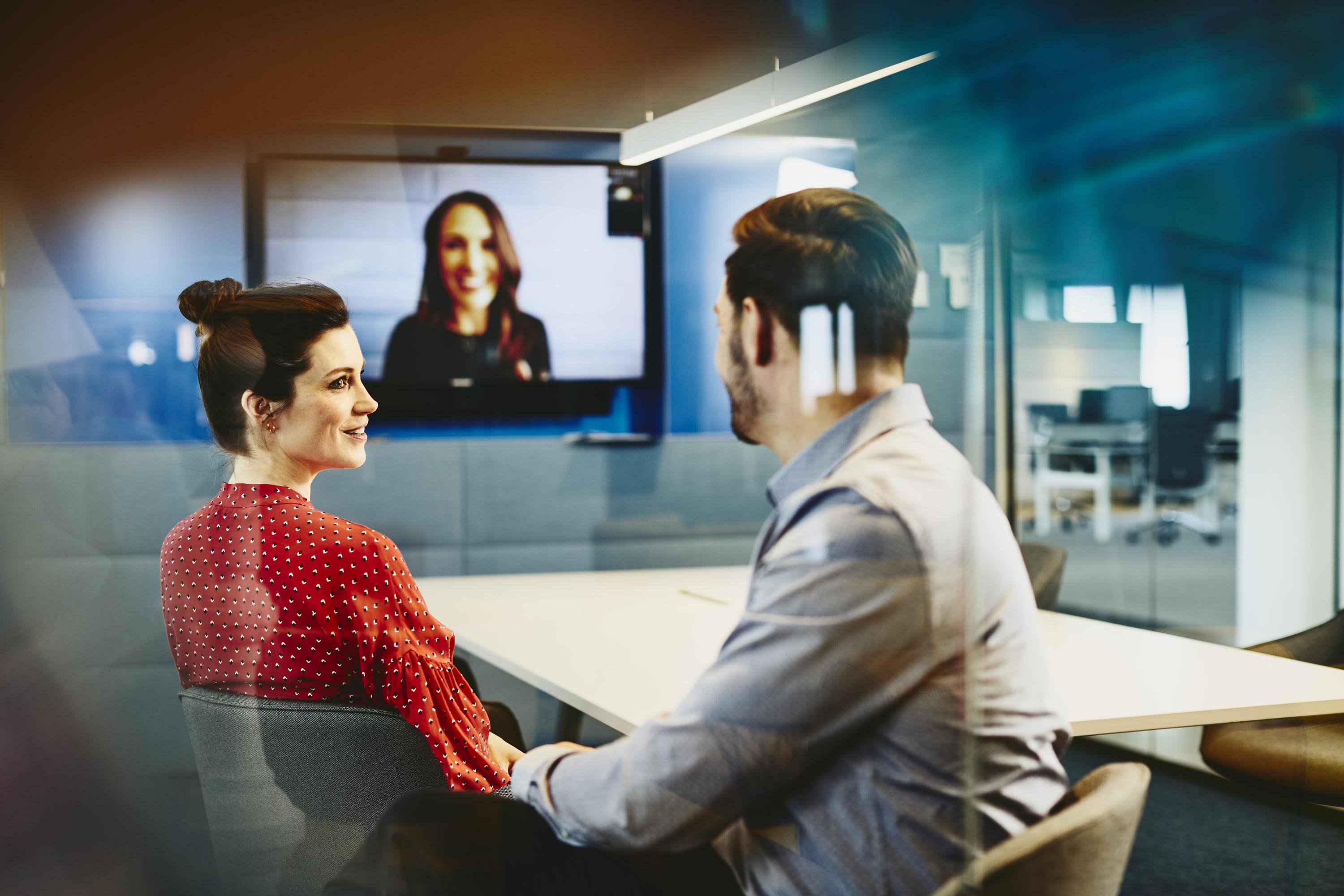 Man and woman in an office having a Hangout. Primary color: blue.