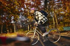 Cycling man, autumn trees on the background.