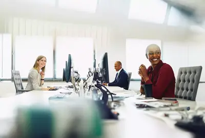 Two female and a male are working on their desk