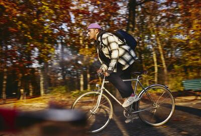 Cycling man, autumn trees on the background.