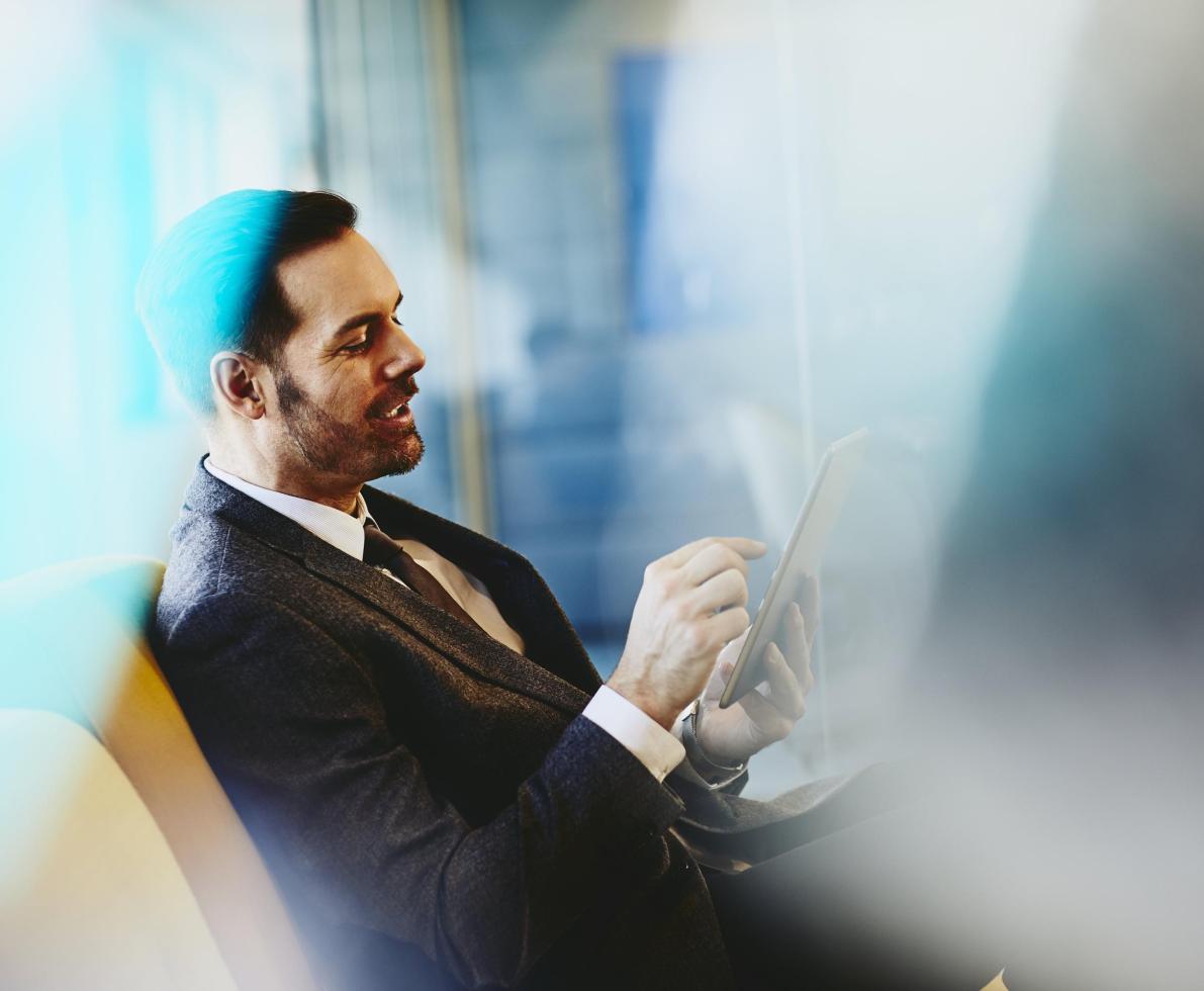 Man in suit with tablet. Primary color: blue. Man in suit with tablet. Primary color: blue.