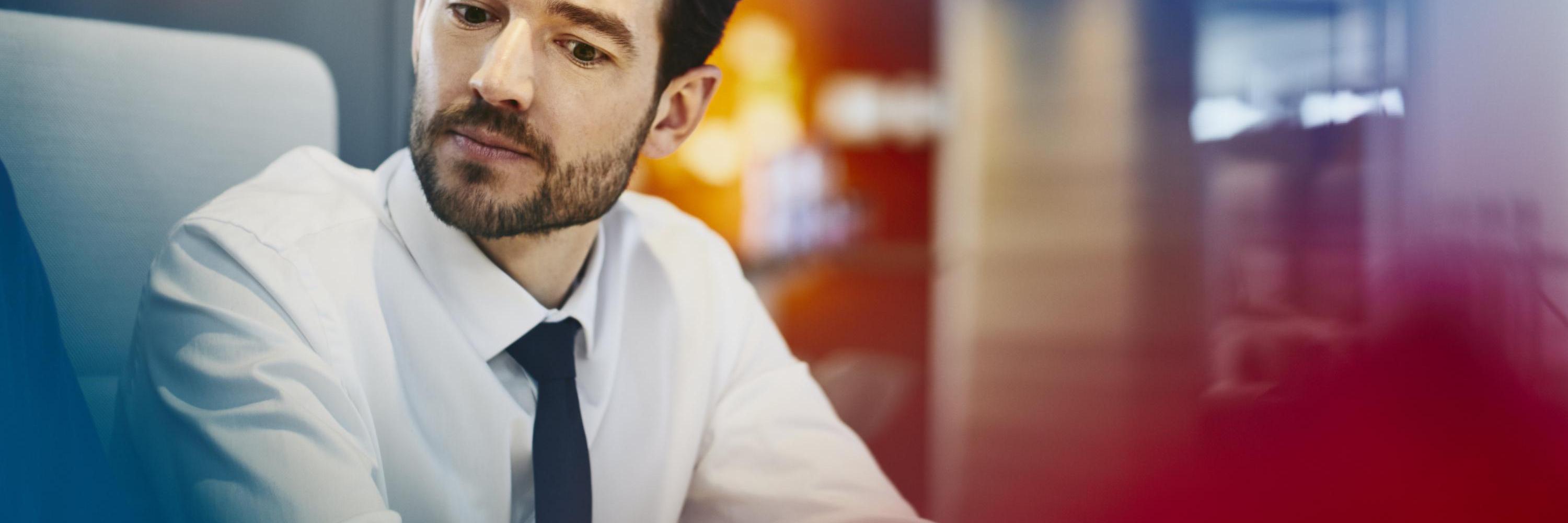 Man with tie listening. Primary color: red.